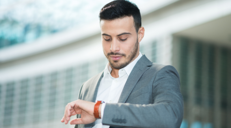 A person glancing at a classic leather-strap watch; A smartphone displaying multiple unread notifications; A calm person writing in a notebook.